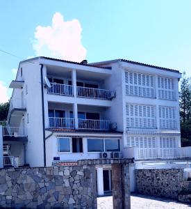 um edifício de apartamentos branco com uma parede de pedra em Villa Helena em Dramalj