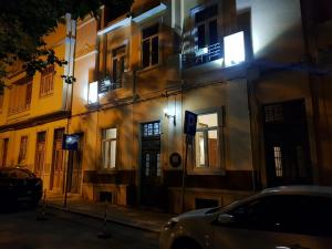 un edificio di notte con un'auto parcheggiata accanto di Guest House do Largo a Faro