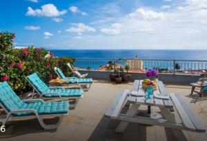 une terrasse avec des chaises et une table et l'océan dans l'établissement TRIPLEX TERRASSE VUE EXCLUSIVE SUR L OCÉAN ,WIFI, à Santa Cruz
