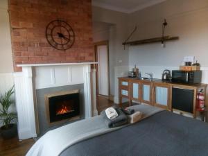 a living room with a fireplace and a kitchen at The Station House in Sheffield