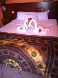 uma cama com dois cisnes envoltos em toalhas brancas em Villa Victoria em Trou dʼ Eau Douce