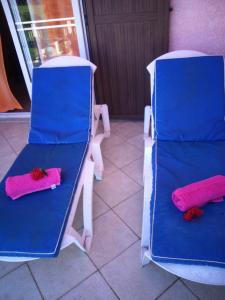 Dos sillas azules con almohadas rosas. en Villa Victoria, en Trou d'Eau Douce