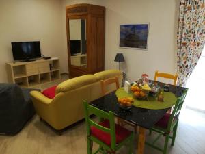 un soggiorno con divano e tavolo con frutta di Augusta Isola Appartamento in Pieno Centro ad Augusta