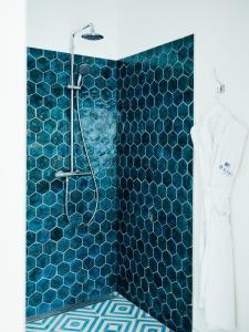 a bathroom with a shower with blue tiles at Havgrim Seaside Hotel 1948 in Tórshavn +54 photos