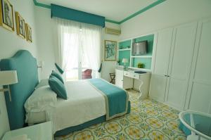 a bedroom with a bed and a desk and a television at Albergo Gatto Bianco in Capri