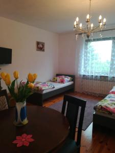 a living room with two beds and a table with flowers at Pokoje Gościnne Lawenda in Sandomierz