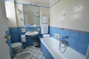 un bagno blu e bianco con vasca e lavandino di Albergo Gatto Bianco a Capri