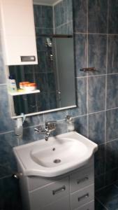 bagno con lavandino bianco e specchio di S&G Apartment a Vranje