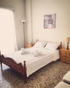 a bedroom with a large bed with white sheets and pillows at Irene's Apartment in Artemida