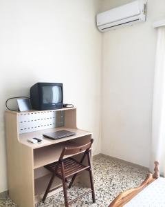 a room with a desk with a tv and a chair at Irene's Apartment in Artemida