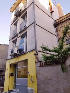 ブカレストにあるSleep Inn Hostelの黄色い扉が目の前にある建物