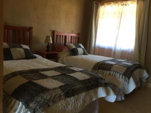 a bedroom with two beds and a window at Hotel Parador Vichuquen in Vichuquén