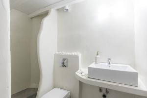 uma casa de banho branca com um lavatório e um WC em Melina's House Mykonos Town em Míconos