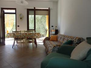 ein Wohnzimmer mit einem Sofa und einem Tisch in der Unterkunft Casetta tra gli Ulivi vicina al Mare in Giustenice