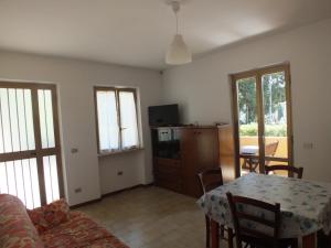 a living room with a table and a dining room at Appartamento Fornaci in Marina di Campo