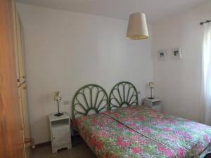 a bedroom with a bed and two night stands at Appartamento Fornaci in Marina di Campo