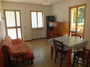 a living room with a table and a dining room at Appartamento Fornaci in Marina di Campo