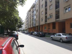 a street with cars parked on the side of a building at Apartment Azzuro 2 in Novi Sad