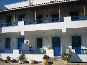 a large white building with blue doors and balconies at Studio nikolos in Elafonisos +7 photos
