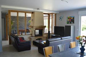 a living room with a couch and a fireplace at Maison individuelle in Brette-les-Pins