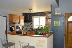 a kitchen with a counter and chairs in it at Maison individuelle in Brette-les-Pins +4 photos