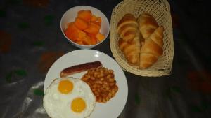 un plato con un huevo y frijoles y un tazón de fruta en Orchid Home Bed & Breakfast pvt ltd, en Katmandú