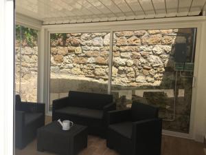 Habitación con 2 sillas y pared de piedra. en The shabby house, en Anzio