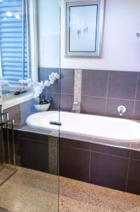 a bath tub in a bathroom with a mirror at Corrugated Cottage in Dunkeld