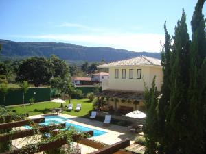 eine Villa mit einem Pool und einem Haus in der Unterkunft Don Quixote Pousada in Tiradentes