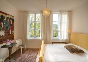 a bedroom with a bed and a table and windows at Loft in alter Schule in Schleiden