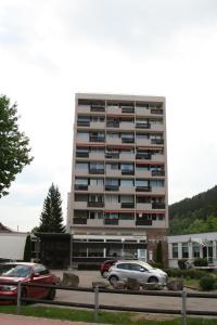 un edificio alto con coches estacionados frente a él en Ferienwohnung an der Alb en St. Blasien