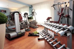 um ginásio com um monte de equipamento de exercício numa sala em Starhotels Vespucci em Campi Bisenzio