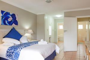 a bedroom with a large bed and a bathroom at La Pirogue 19 in Ballito