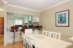 a kitchen and dining room with a table and chairs at La Pirogue 19 in Ballito