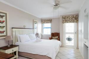 a bedroom with a large white bed and a chair at Le Paradis 22 in Ballito