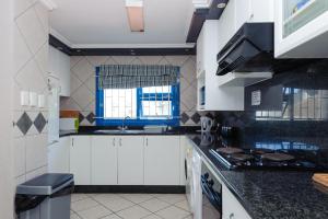 a kitchen with white cabinets and a window at Le Paradis 22 in Ballito