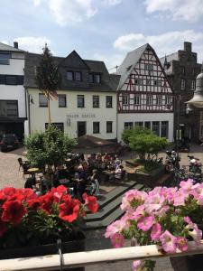 eine Gruppe von Menschen, die vor einem Gebäude sitzen in der Unterkunft Pension "Am Markt" in Treis-Karden