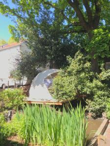a boat is docked in a yard under a tree at Vintage Dome Igloo tent, Lange Haven Schiedam in Schiedam