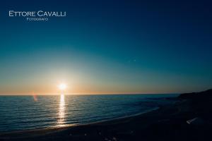a sunset over the ocean with the sun setting at Hotel Corsaro Nero in Portu Maga