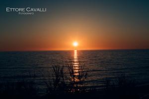 a sunset over the ocean with the sun setting at Hotel Corsaro Nero in Portu Maga