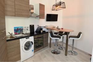 uma cozinha com uma mesa e uma máquina de lavar roupa em Le Sémaphore em Saint Malo