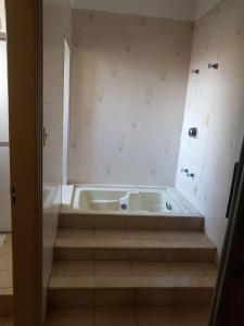 a bath tub sitting in a bathroom with stairs at Scala Hotel Barretos in Barretos