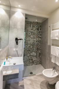 ein Bad mit einer Dusche, einem Waschbecken und einem WC in der Unterkunft San Lorenzo Apartments in Sirmione