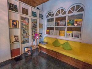 a room with a yellow couch and posters on the wall at The Mango in Kandy