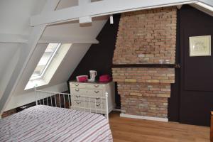 a attic room with a brick wall and a staircase at Huyze Peerdenbrugghe in Bruges
