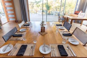 uma longa mesa de madeira com pratos e guardanapos em Truffle Lodge Dinner Bed Breakfast Glamping em Gretna