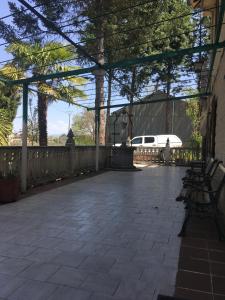 a patio with benches and a fence and a car at Casa Rural Camino Medulas in Ponferrada