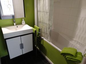 un bagno con un lavandino, una vasca da bagno e un lavandino di Huyze Peerdenbrugghe a Bruges