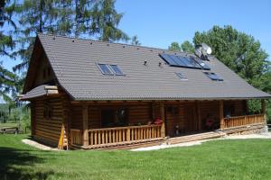 una baita di tronchi con tetto a dondolo e veranda di Penzion-Ranc u Trapera a Hrabušice