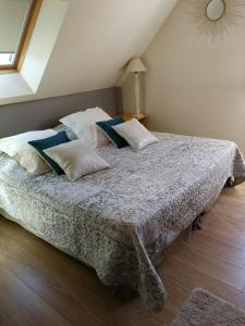 a bedroom with a bed with white and blue pillows at Villa Rose in Escolives-Sainte-Camille